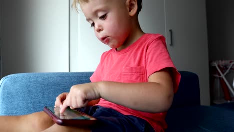 Content-kid-playing-smartphone-on-sofa