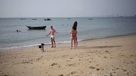 Lustige-niedliche-männliche-schwule-Metrosexual-in-einem-rosa-T-Shirt-und-blauen-Shorts.-Familie-schießt-Video-am-Strand