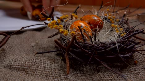 Hand-putting-quail-eggs-in-easter-nest