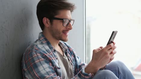 Relaxed-man-messaging-on-mobile-phone