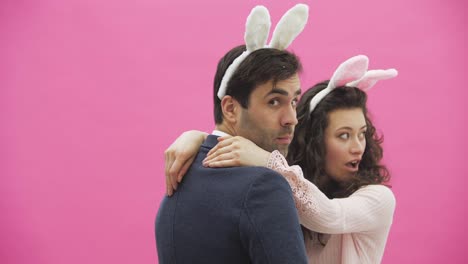 Beautiful-young-girl-standing-on-a-pink-background.-During-this,-there-are-ears-of-rabbits-on-the-head.-Swing-heads-to-each-other-like-bunnies.