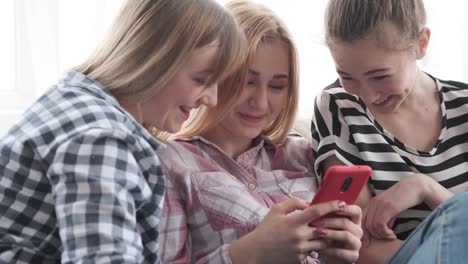 Chicas-adolescentes-disfrutando-de-contenido-multimedia-en-el-teléfono-móvil