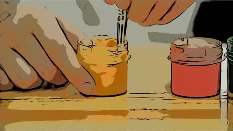 Creative-boy-is-mixing-and-stirring-yellow-paint-in-a-jar-with-a-help-of-nude-paint-brush.