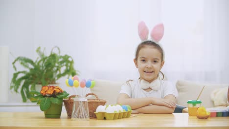 La-pequeña-chica-linda-y-adorable-está-sonriendo-sinceramente.-La-chica-está-bombeando.-Concepto-vacaciones-de-Pascua.