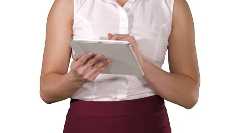 Woman-holding-digital-tablet-and-using-it-while-walking-on-white-background