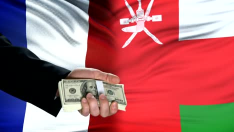 Frankreich-und-Oman-Beamte-tauschen-Tank-gegen-Geld,-Flagge-Hintergrund-Verhandlungen