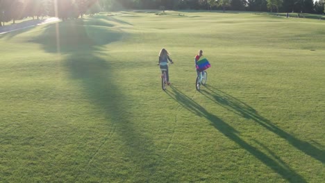 Aerial-shot-of-gay-couple-riding-bikes-across-lawn