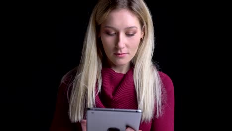 Closeup-shoot-of-young-pretty-caucasian-female-using-the-tablet-in-front-of-the-camera