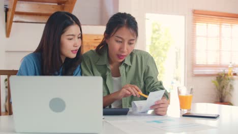 Business-Asian-Lesben-Paar-mit-Taschenrechner-Rekord-Budget,-Steuer,-Finanzdokument-auf-Laptop-in-der-Küche-arbeiten.