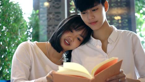 Close-up-Young-Asian-lesbian-couple-reading-a-book-together