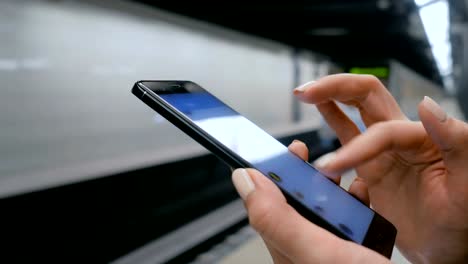 Frau-mit-Smartphone-auf-U-Bahn-Plattform