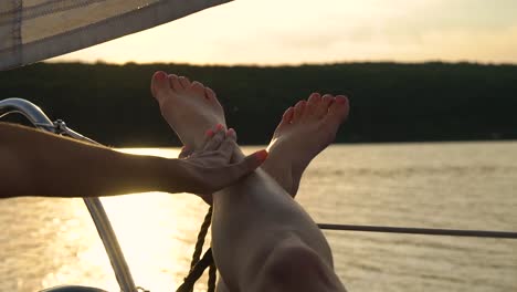 lesbian-hands-touching-legs-of-her-partner-relaxing-on-sailboat