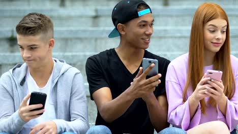 Freunde-chatten-soziale-Netzwerke-auf-Handys-im-Freien,-freudige-teen-teilen-Nachrichten