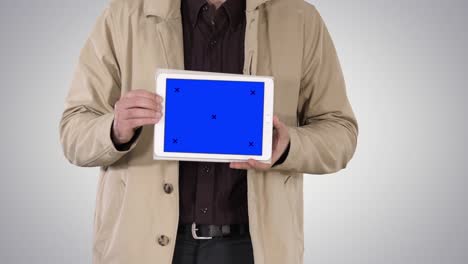 Male-hands-holding-tablet-with-blue-screen-mockup-on-gradient-background