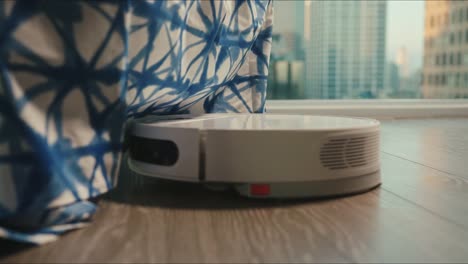 Close-up-of-the-robotic-vacuum-cleaner-riding-around-and-cleaning-up-apartments