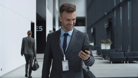 Businessman-Using-Phone-in-Airport