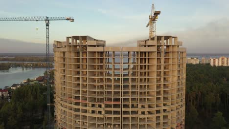 4k-Vista-aérea-grandes-grúas-de-construcción-y-casa-inacabada