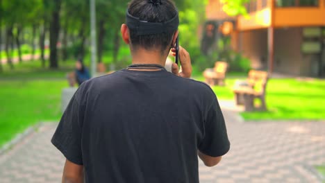 back-view-guy-has-phone-conversation-on-the-run