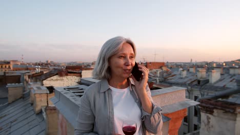 Turista-femenino-de-pelo-gris-teniendo-una-charla-telefónica-en-el-techo