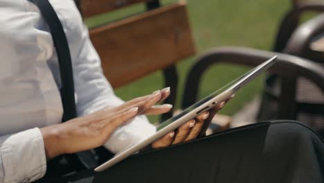 Woman-Reading-Tablet-Device.-A-young-Spanish-adult-female-latina-online-shopping-booking-outdoor-on-street,-airport-terminal