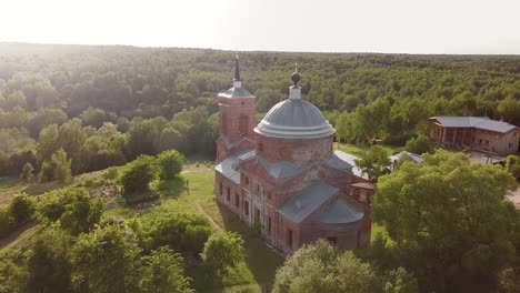 Aerial-view-of-the-Russian-forest,-river-and-steppe-overlooking-an-abandoned-Church-and-architectural-objects