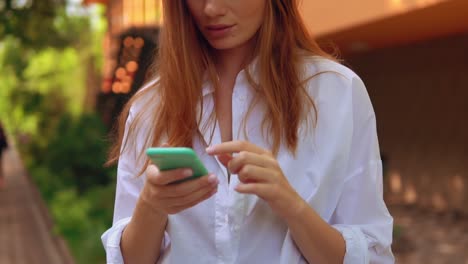 close-up-female-with-headphones-holding-mobile-outdoor