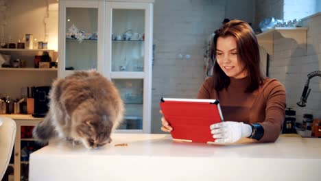 Young-woman-with-a-bionic-hand-and-a-cat-near-her