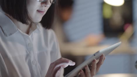 Asiatische-Geschäftsfrau-mit-Tablet-in-Dark-Office