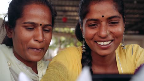 Two-women-chilling-sipping-drinks-using-technology-in-cafe