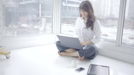 interior-casa-de-mujer-árabe-con-tecnología-móvil-de-redes-sociales-feliz-relajada