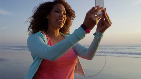 African-American-female-using-smart-phone-ear-buds