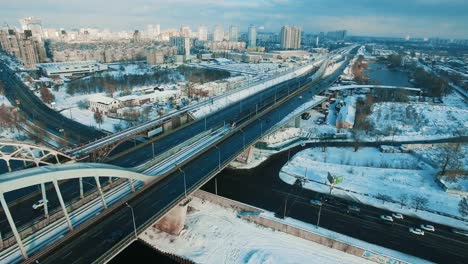 Cars-and-train-moves-on-a-bridge-over-a-frozen-river-aerial-drone-footage