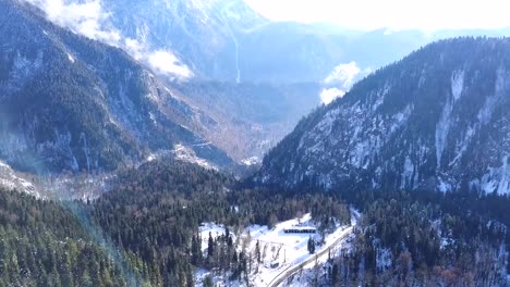 Panoramic-view-of-beautiful-white-winter-wonderland-scenery-with-snowy-mountain-summits.-Clip.-Cold-sunny-day-with-blue-sky-and-clouds