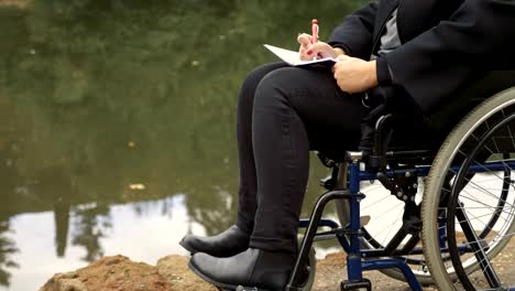 close-up-on-sad-and-lonely-woman-on-the-wheelchair-writes-her-diary