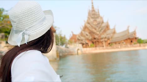 Frau-Tourist-in-Hut-und-eine-Sonnenbrille,-die-Hauptdarsteller-zum-alten-Tempel.-Folgen-Sie-mir-Konzept