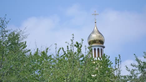 Eastern-orthodox-crosses-on-gold-domes-cupolas-against-blue-cloudy-sky