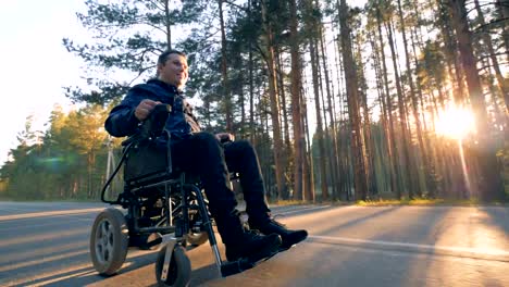 Un-hombre-en-silla-de-ruedas-toma-un-paseo-en-un-camino-forestal.