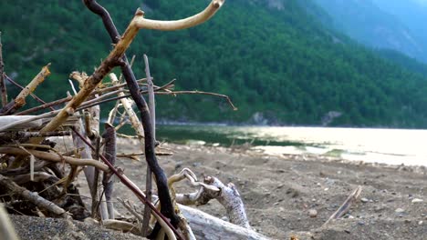 Young-riders-on-horseback-wander-along-the-sandy-shore-of-a-mountain-lake.