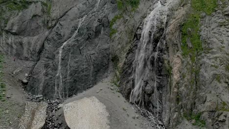 Tracking-and-top-shot-Air-shot-from-a-stream-of-water-splashing-waterfall-on-a-rock-wall-in-the-Caucasus-Mountains.-Around-the-jet-of-the-waterfall