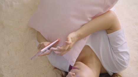 Asian-woman-using-cellphone-in-living-room