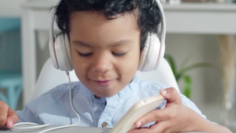 Little-Boy-in-Headphones-Enjoying-Music-on-Smartphone