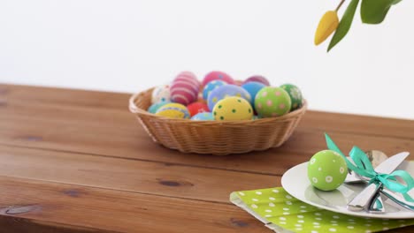 easter-eggs-in-basket-and-flowers-on-served-table