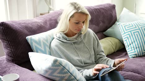 Hermosa-rubia-dama-relajante-en-el-hogar-con-Tablet-PC