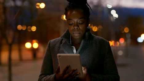 Mujer-africana-con-la-tableta-en-la-noche