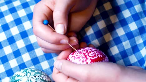 girl-hands-detail,-which-engraves-Easter-ornaments-on-colored-eggs,-with-engraving-technique,-typical-custom-of-Eastern-Europe,-Easter-footage-4K