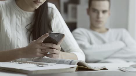 Niña-hablando-con-su-teléfono-y-haciendo-caso-omiso-de-su-novio