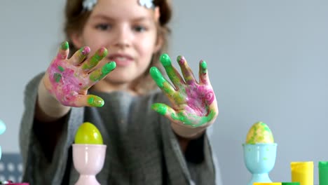 El-cierre-de-las-manos-de-una-niña-sucia-en-pintura-multicolor