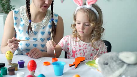 Mother-Helping-her-Daughter-to-Color-Wooden-Bunny