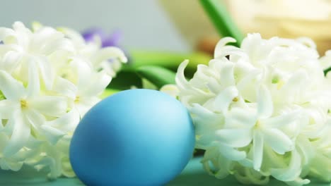 Blue-easter-eggs,-candles-and-white-hyacinth-on-blue-concrete-table-surface-background,-copy-space-for-you-text.-Festive-background.-Happy-Easter-greeting-card.