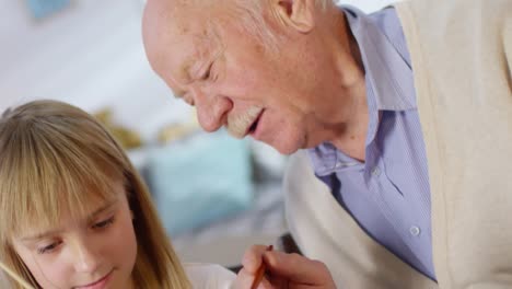 Adorable-Girl-and-Grandfather-Decorating-Eggs